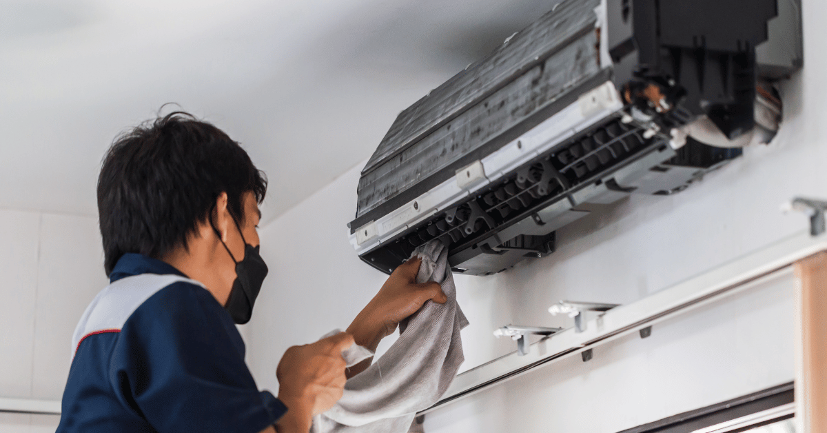 homem limpando ar condicionado com um pano
